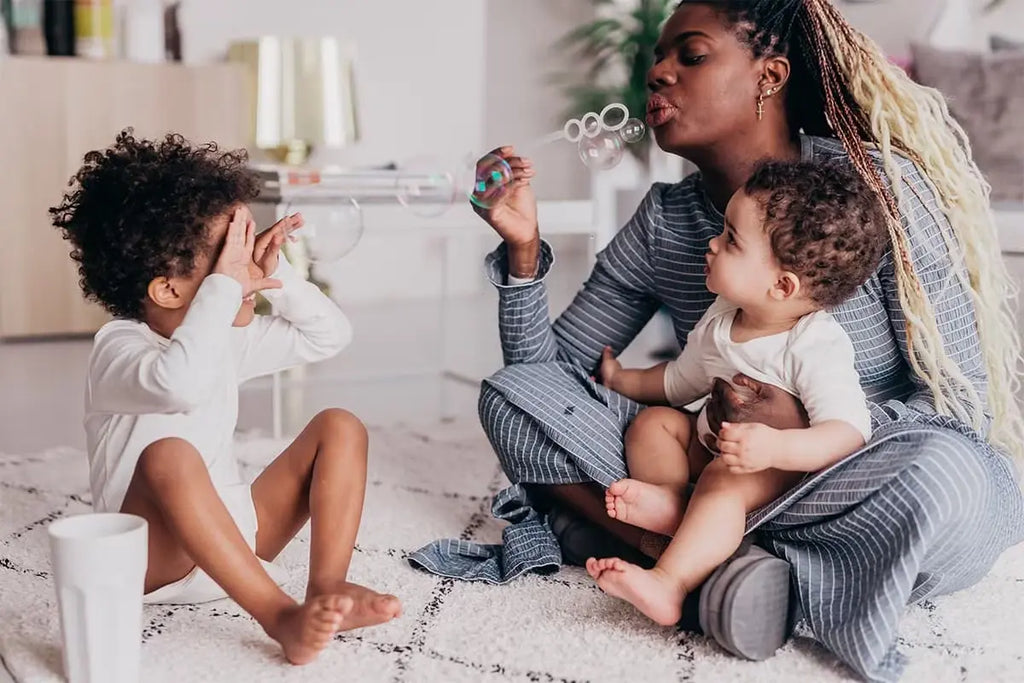 Madre haciendo pompas con sus hijos
